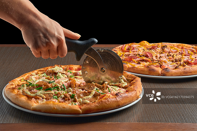 用刀切披萨的手图片素材
