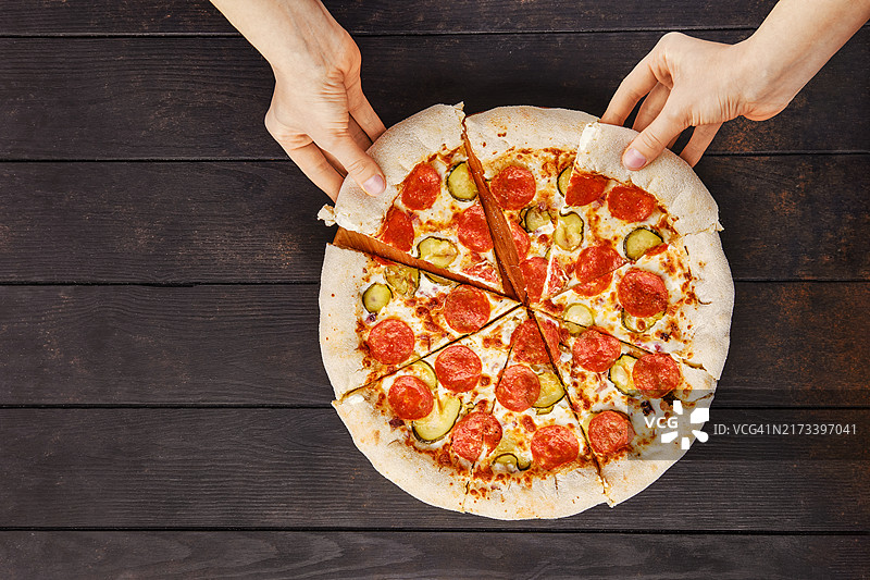 俯视双手从盘子里拿披萨图片素材