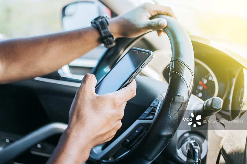 在他的车里使用手机的人，使用手机的司机手部特写，司机手触摸手机屏幕的概念图片素材