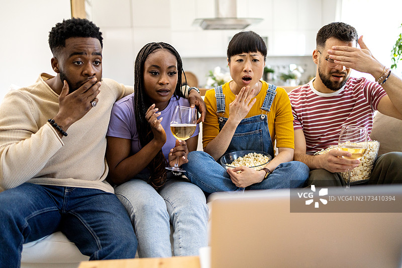 一群多元化的朋友在笔记本电脑上观看电影图片素材