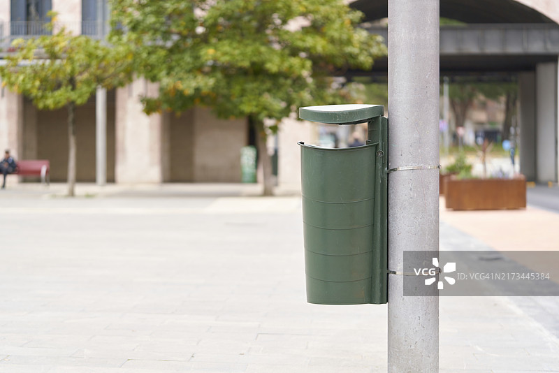 城市背景中的绿色垃圾桶图片素材