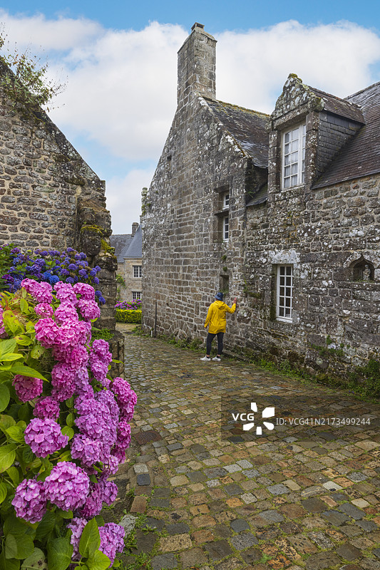 在法国洛克罗南历史中心美丽街道上散步的女人图片素材