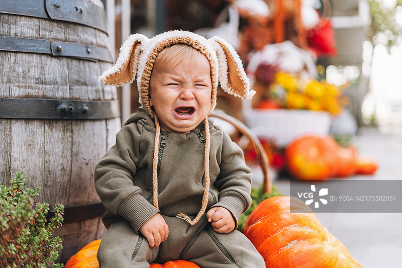坐在南瓜上哭泣的可爱男婴图片素材