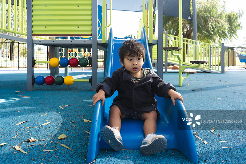 在户外游乐场滑梯上玩耍的幼儿图片素材