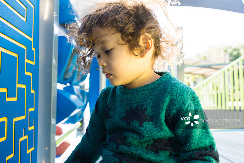 在户外游乐场滑梯上玩耍的幼儿图片素材