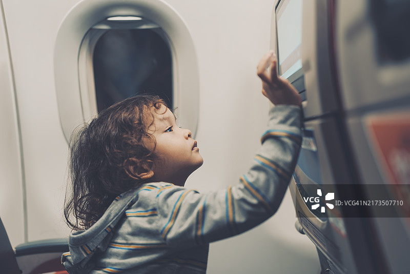在飞机上使用娱乐设施的孩子图片素材