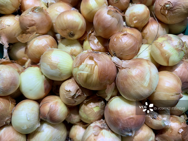 曼谷市场上带皮的黄色洋葱堆图片素材