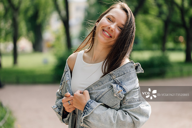 站在公园里，面带灿烂笑容的美丽棕发女子图片素材