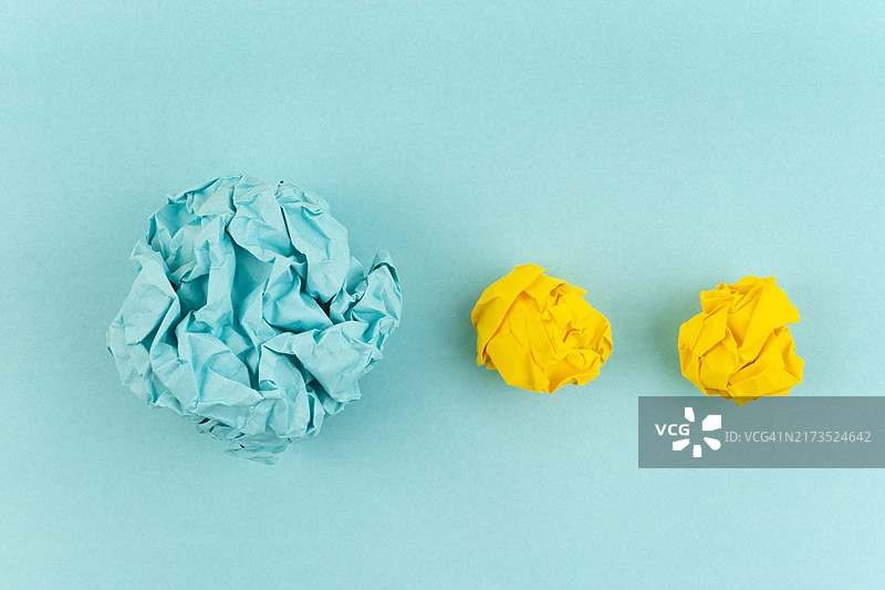 蓝色背景上的蓝黄色皱纸球图片素材