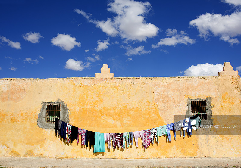 阳光下砖房上晾晒的摩洛哥衣服图片素材