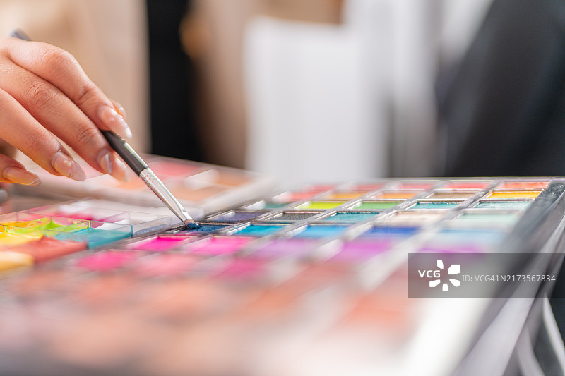 化妆师用刷子使用眼影盘图片素材