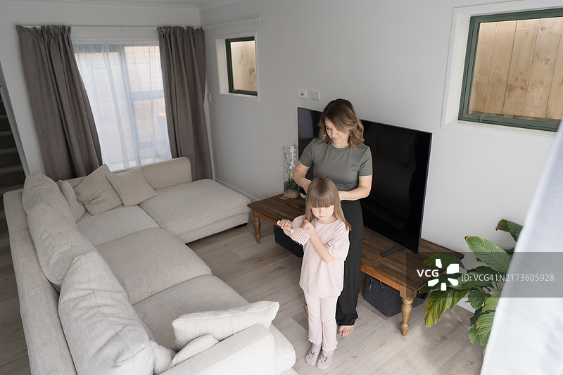 母亲帮助女儿梳理头发，回忆往昔。图片素材