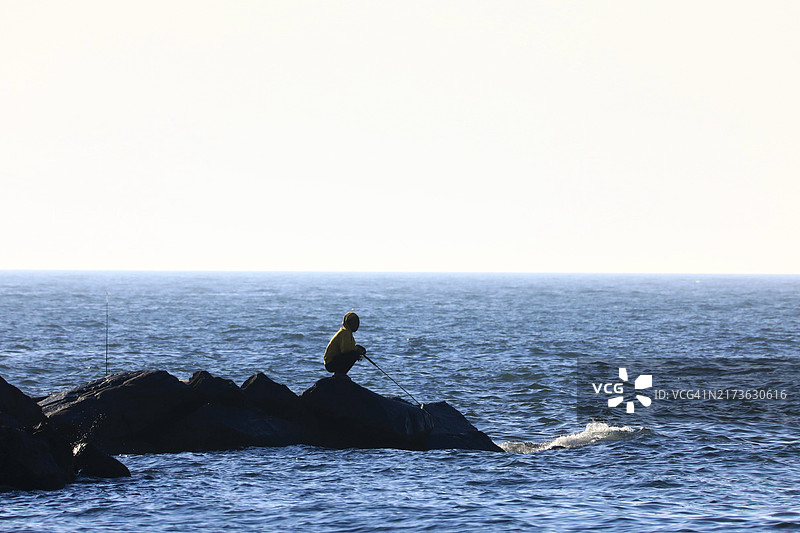 在海岸线岩石上钓鱼图片素材