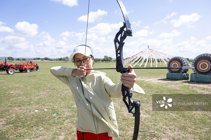 女人在草原上拍摄儿子图片素材