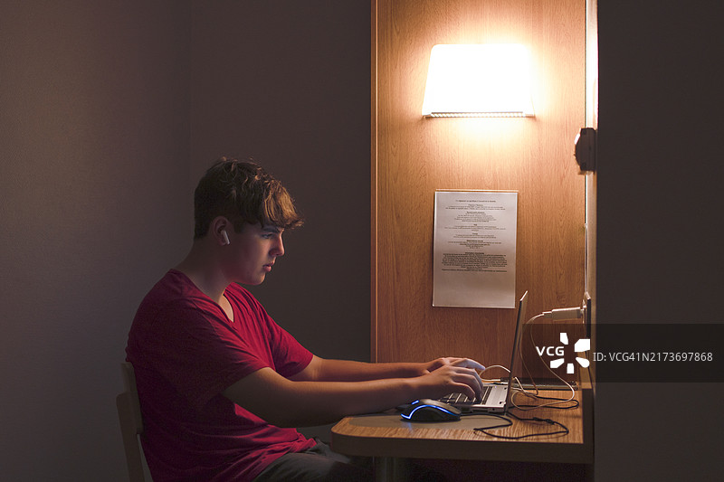 在舒适的酒店房间里深夜使用笔记本电脑图片素材