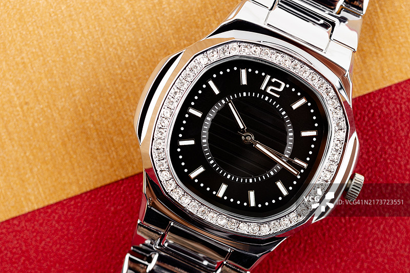 镶钻银色女士计时腕表特写，金色背景图片素材