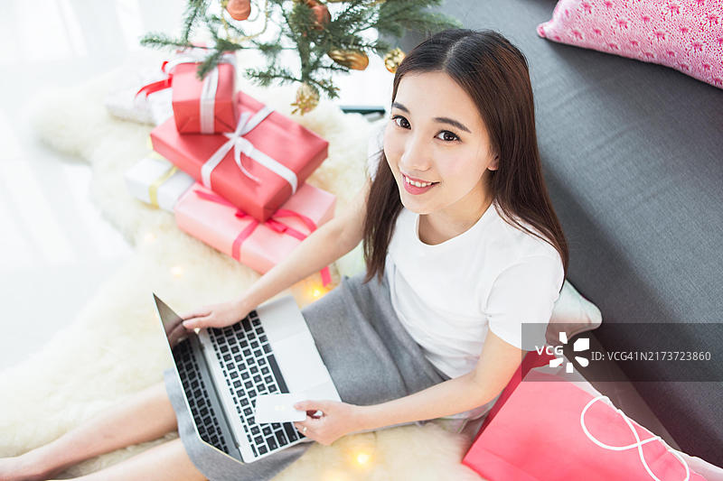 用笔记本电脑和信用卡在线购物的女人图片素材