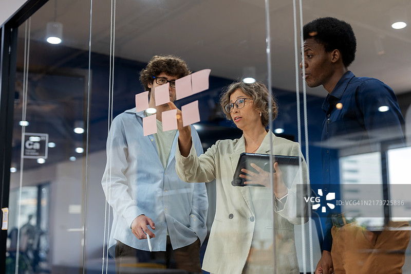 商务拓展团队在现代办公室会议室集思广益，讨论业务流程改进策略图片素材