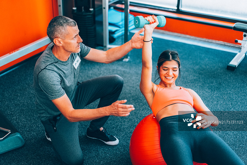 与私人教练一起在健身房锻炼图片素材
