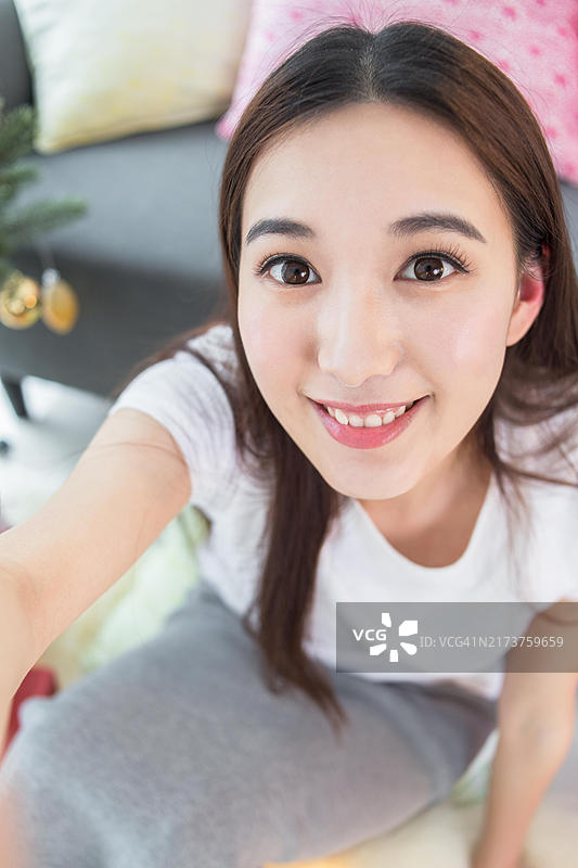 一位女士在圣诞树前自拍图片素材