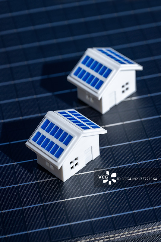 迷你房屋与太阳能电池板放置在太阳能电池表面，突显可再生能源的好处图片素材