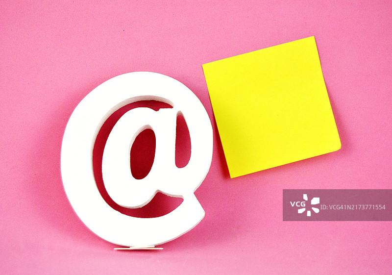 粉色背景上的@符号和黄色便签图片素材