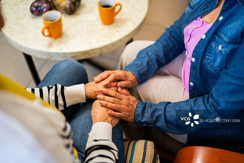 老年朋友在家中手牵手的特写图片素材