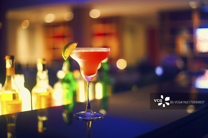 夜间酒吧背景上的草莓玛格丽特鸡尾酒图片素材