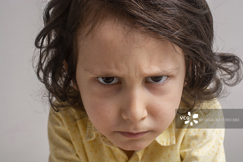 可爱的小男孩试图做一个严肃的表情图片素材