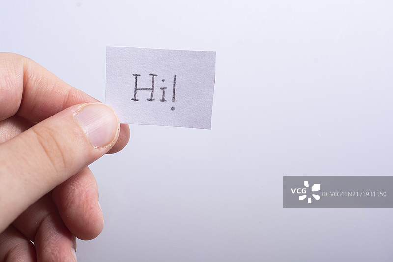 手持写有“HI”字样的便签，白色背景图片素材