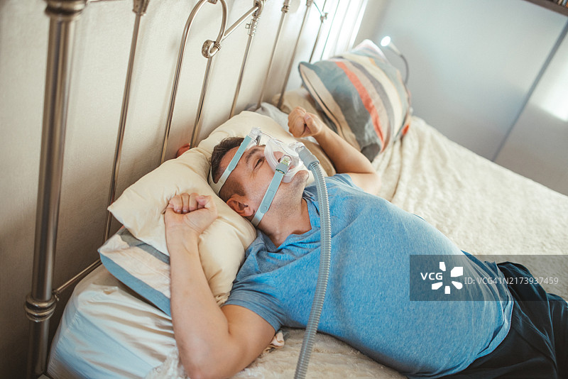 男子戴睡眠呼吸暂停呼吸机图片素材