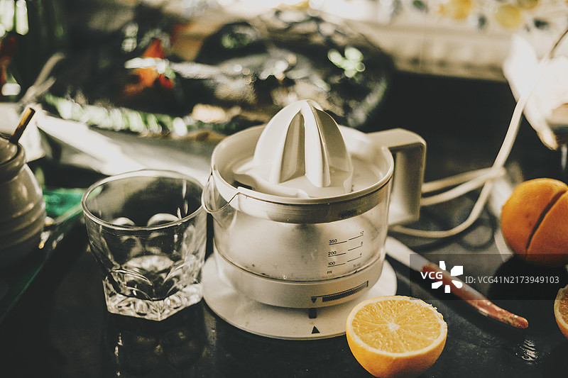 厨房桌上的橙汁榨汁机和橙子切片图片素材