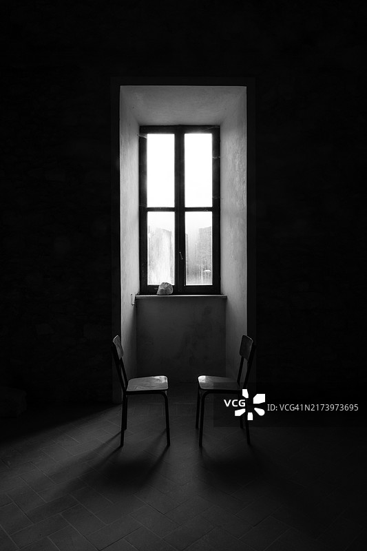 阳光照耀下老窗前的两把空椅子图片素材