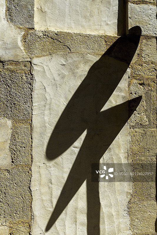 墙上的道路标志影子，法国涅夫勒省图片素材