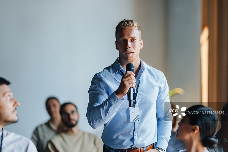 商务会议上与观众互动的自信演讲者图片素材