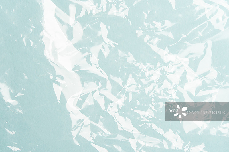 浅蓝色背景上用于包装的褶皱聚乙烯，使用不可持续材料危害地球，带有文案区域的设计背景图片素材