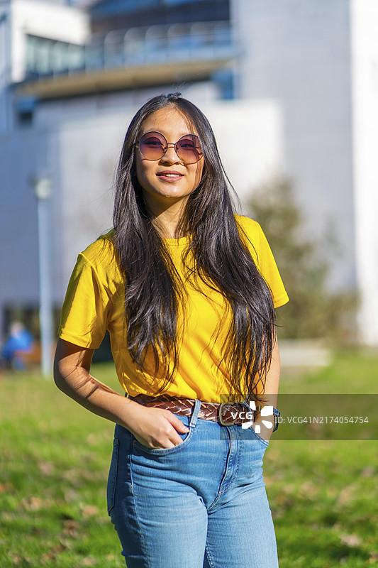 竖版照片：美丽的中国留学生在校园里图片素材
