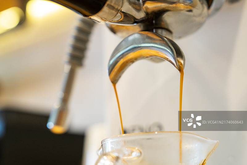 浓缩咖啡从咖啡机倒入咖啡杯的特写镜头图片素材