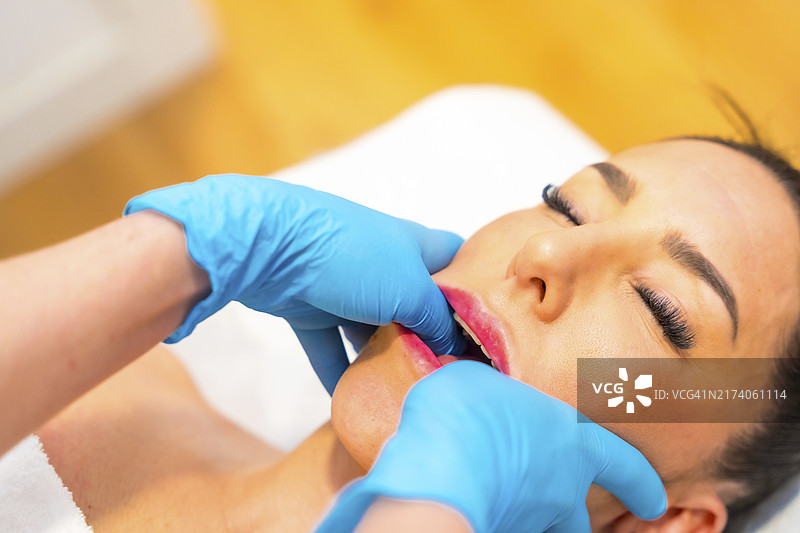 病人接受颌骨按摩治疗紧张和颞下颌关节功能障碍图片素材
