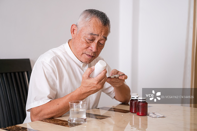 老年男人服药缓解疾病症状，保健概念图片素材