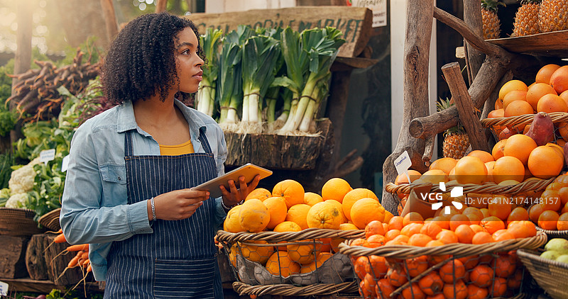 快乐的年轻女店员在店内工作时点击设备，零售概念图片素材