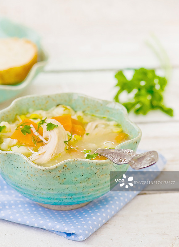 白色碗中的家常鸡汤和饺子，放在木桌上图片素材