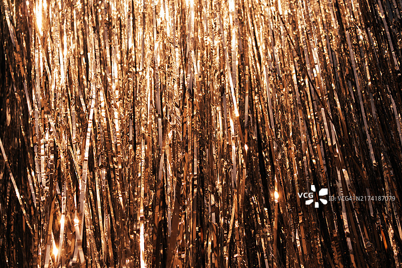 用于任何节日和活动的棕色装饰。闪亮、照明、喜庆的背景，适用于生日、圣诞节、新年或周年纪念日。全画幅，纹理完美。金属雨倾泻闪耀图片素材