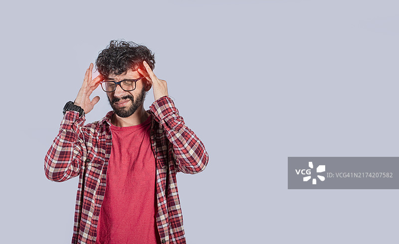 人们捂着头感到难受，头痛的年轻人，男人按摩头部，偏头痛的概念图片素材