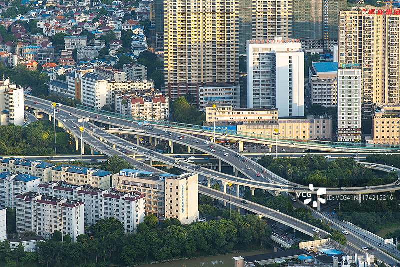 广西南宁俯视图：纵横交错的高速公路和远处的城市建筑图片素材