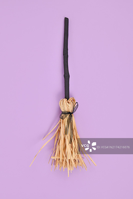 紫色背景上的黑色树枝和稻草女巫扫帚图片素材