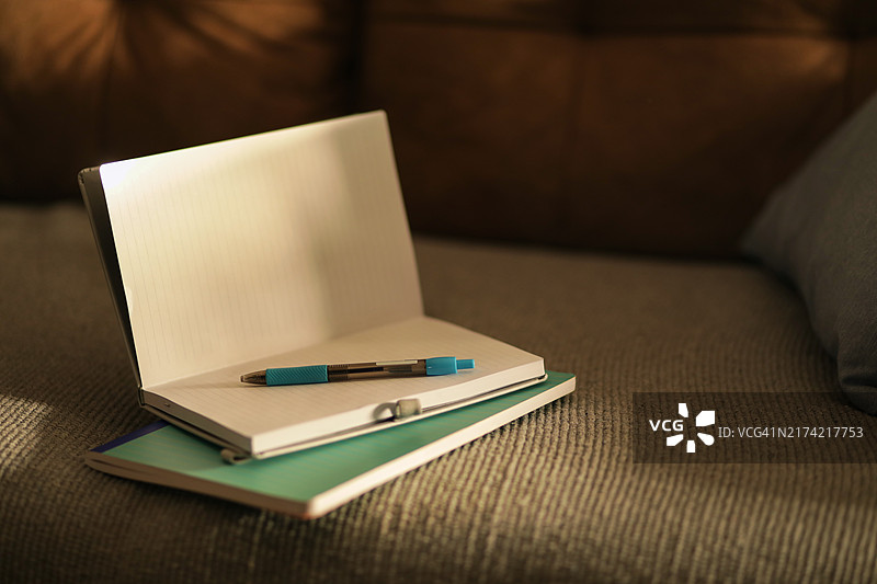 带蓝色笔的打开的笔记本图片素材
