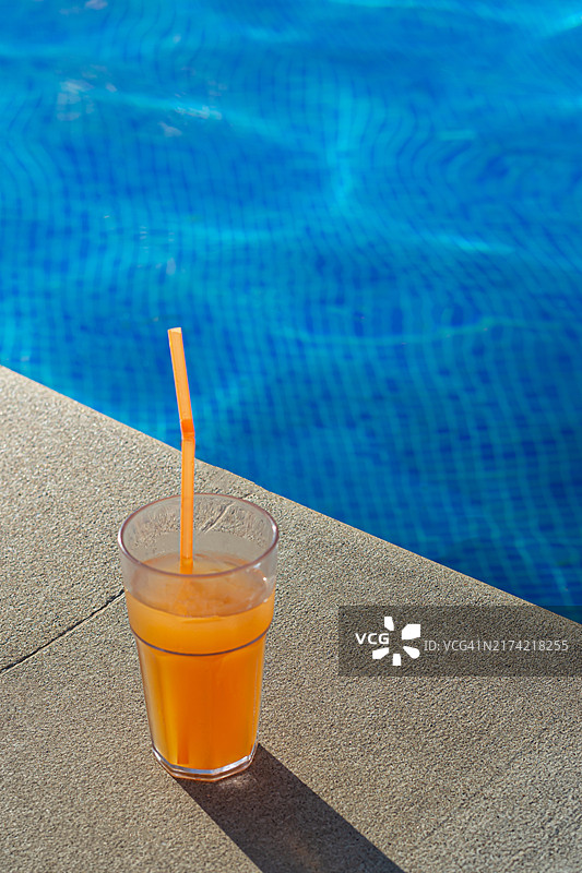 泳池边玻璃杯中的无酒精鸡尾酒，在水边休息度假图片素材