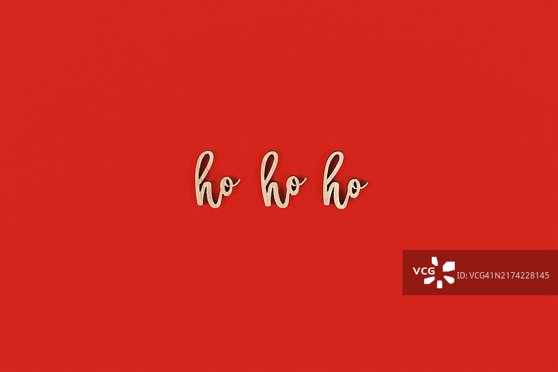 红色背景上的季节性圣诞木制字母“ho ho ho”图片素材