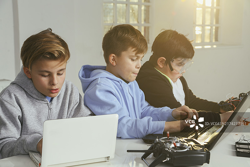 男孩们正在编写遥控模型飞机的程序图片素材
